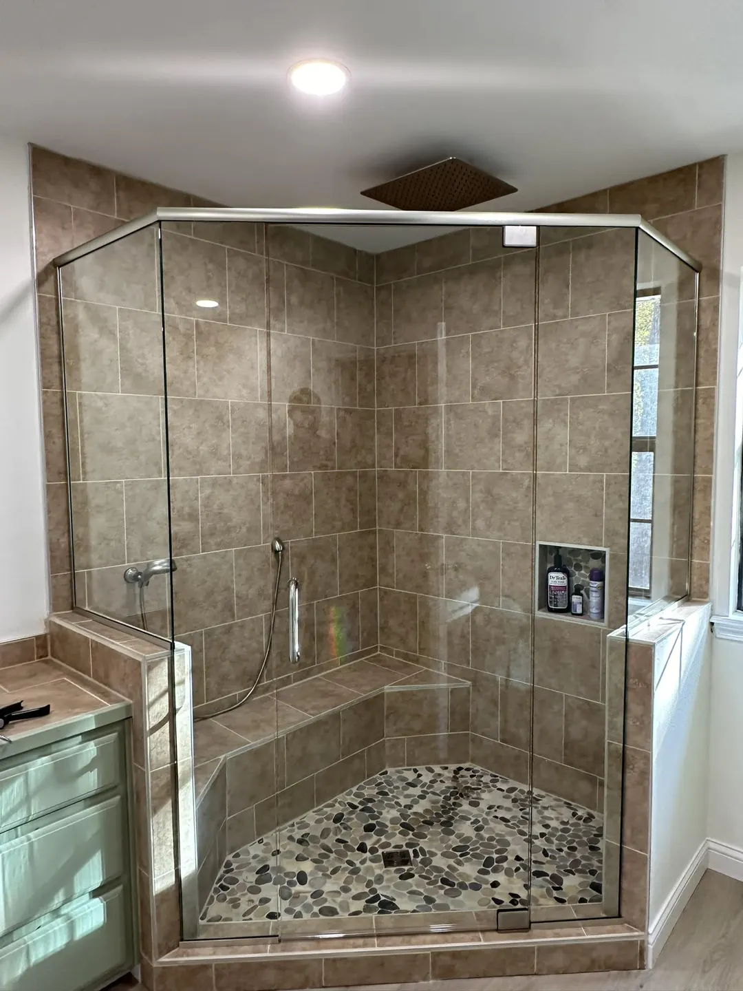 Custom glass shower enclosure following an angled wall